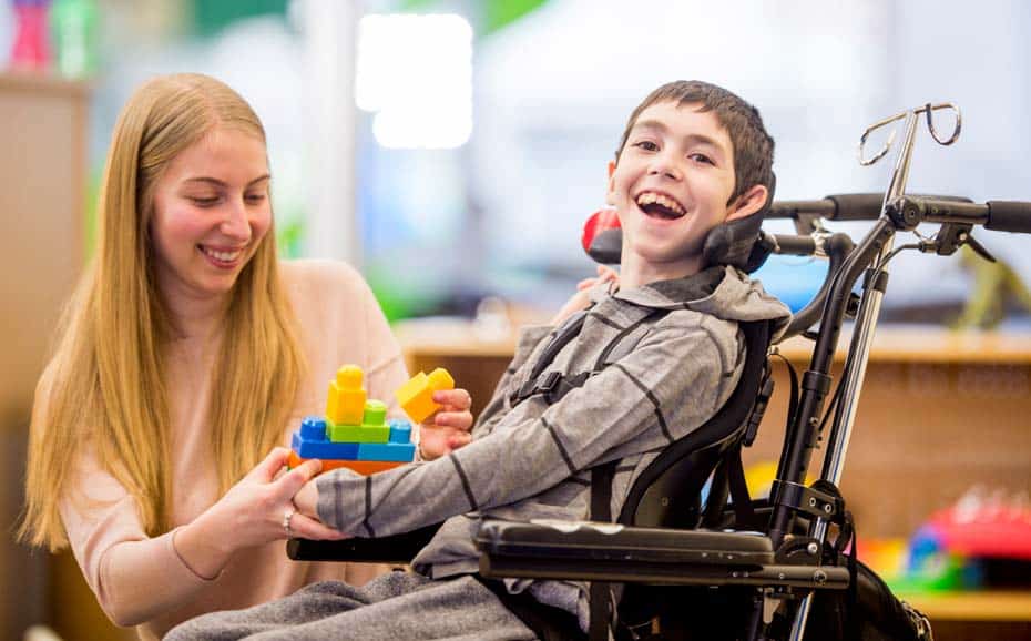 a child smiling playing with their carer in a community facility